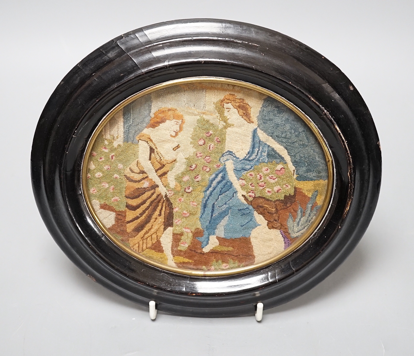 A 19th century oval petit point needlework picture, depicting women collecting flowers 12x15cm